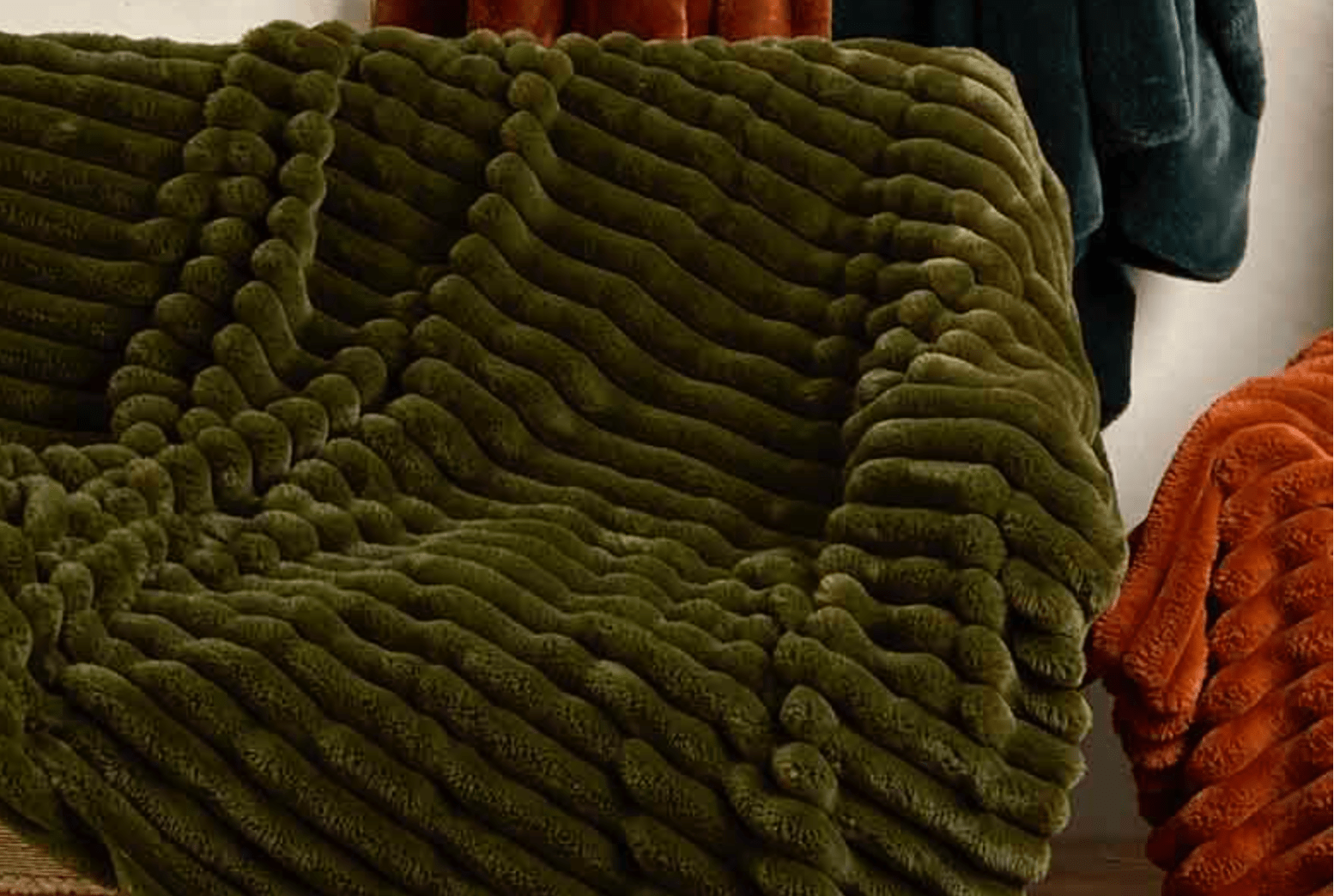 Green textured blanket draped over a surface with a blurred background