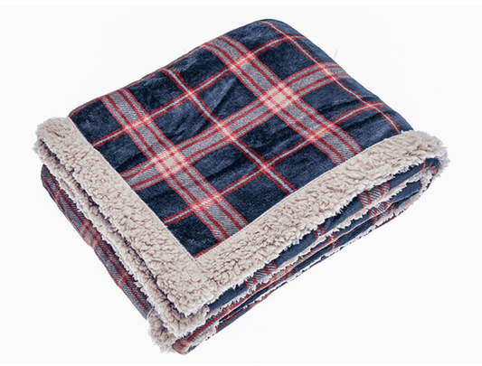 Folded plaid blanket with sherpa lining on a white background