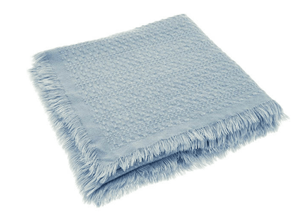 Light blue textured throw blanket with frayed edges on a white background