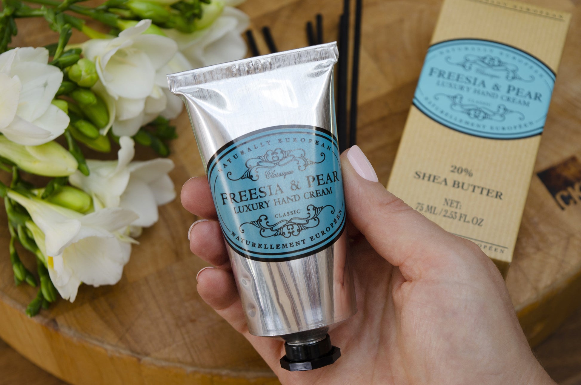Holding the Naturally European Freesia & Pear Luxury Hand Cream by Somerset Toiletry Co. 